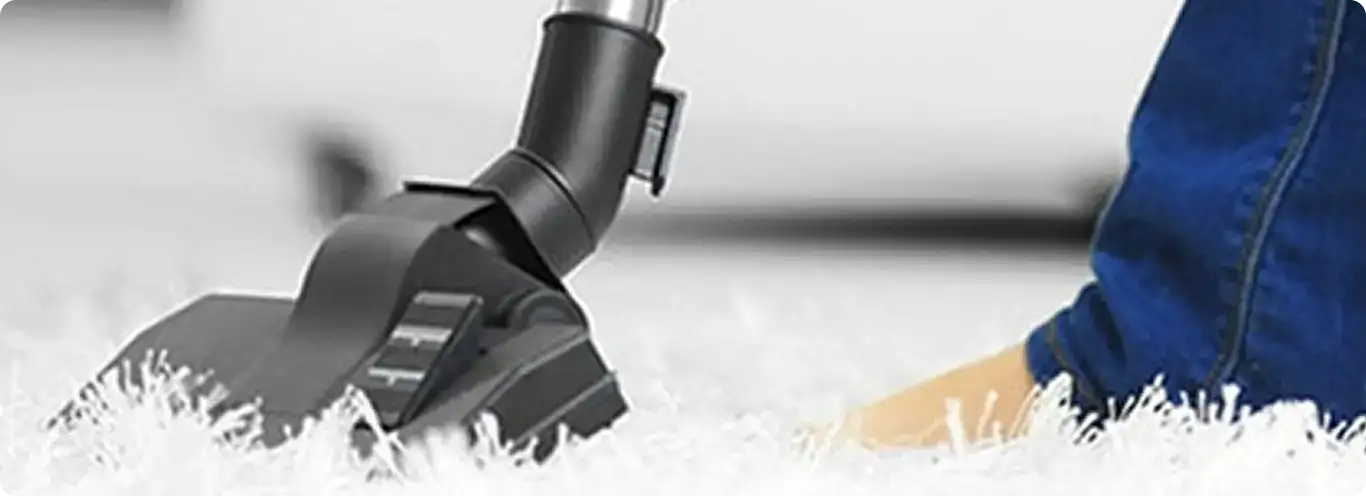 Close-up of a professional vacuuming a white carpet in Fairport.